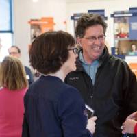A group laughs while talking at the exhibit